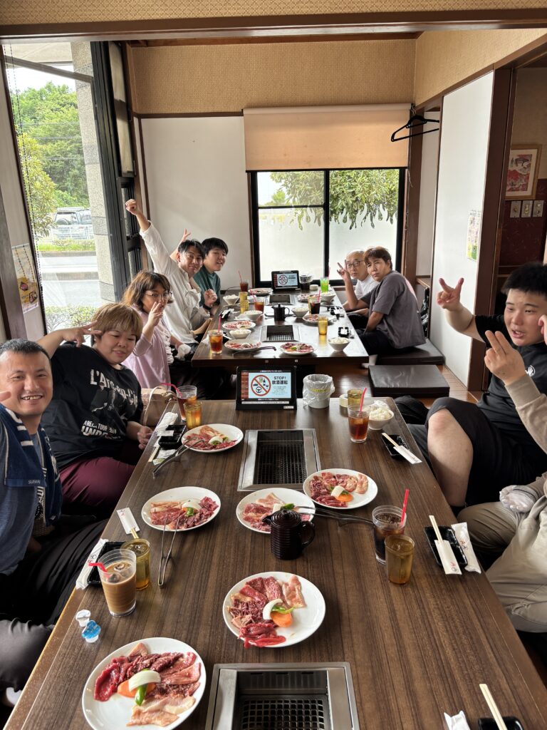 利用者さんと職員で焼き肉を前にピース