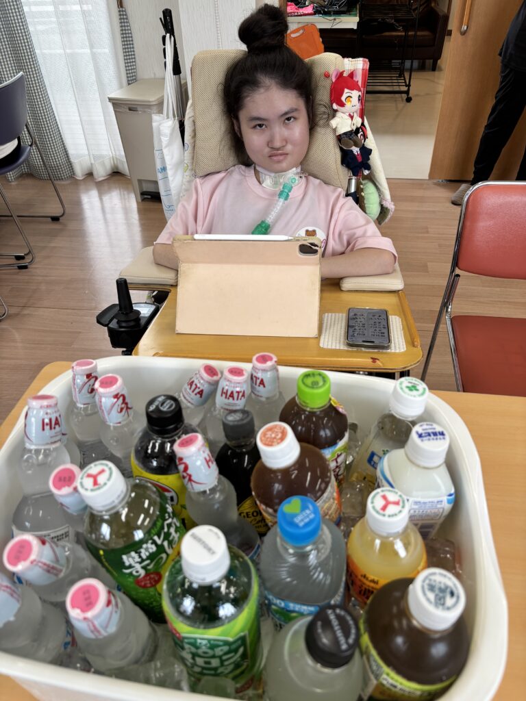 氷水で冷やしているペットボトルの飲み物と車椅子の利用者さん